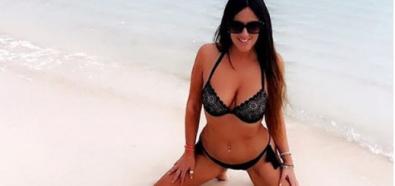 Claudia Romani w czarnym bikini na plaży