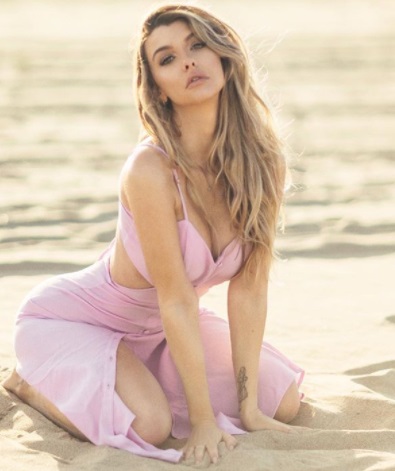 Emily Sears ponętnie w różowej sukience na plaży
