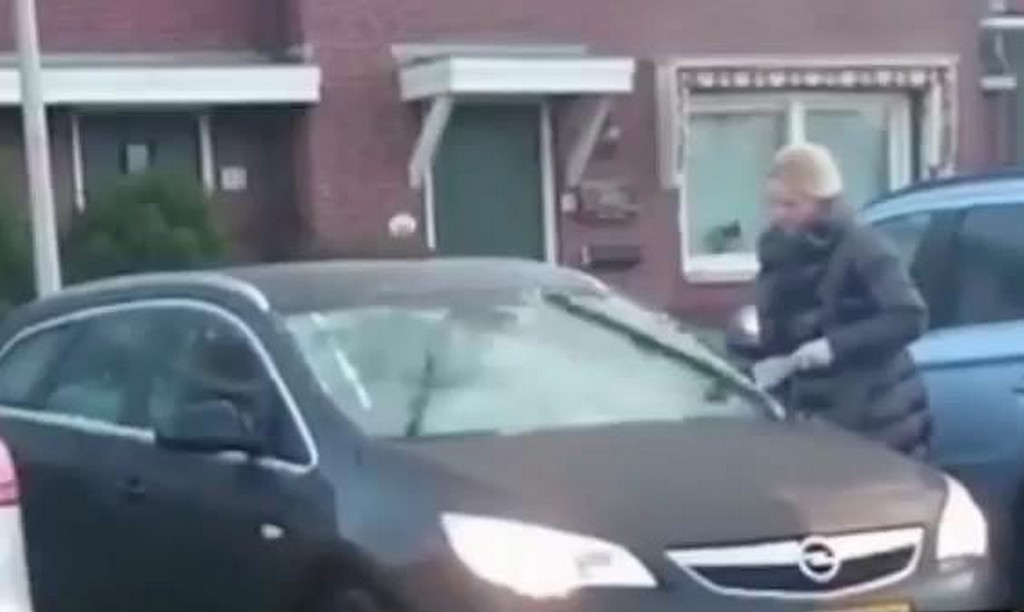Kobieta usuwa lód z szyby auta