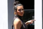 Kim Kardashian z kokiem na głowie i w szarej sukience