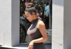 Kim Kardashian z kokiem na głowie i w szarej sukience